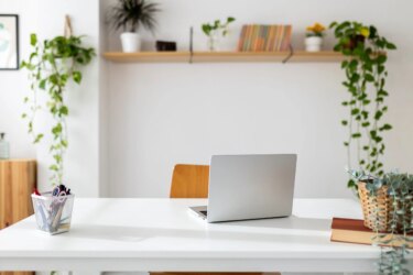 Laptop computer on table in bright room of home office scaled.jpg