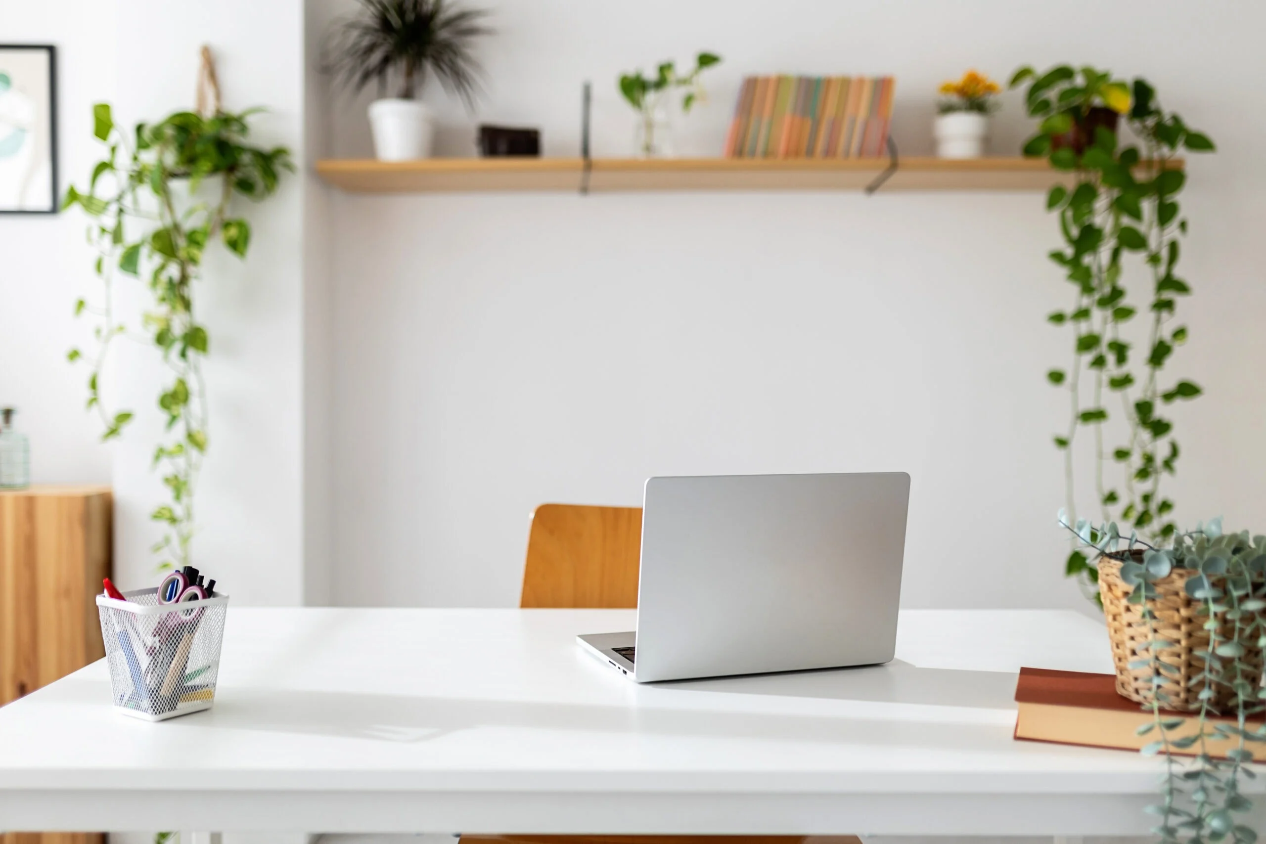 Laptop computer on table in bright room of home office scaled.jpg