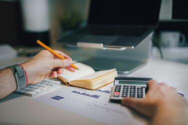 Financial decisions to make before going freelancer calculating finances with a calculator and noteb.jpeg
